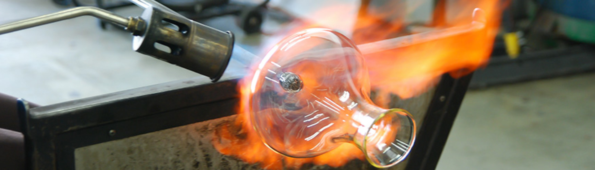 Master glassblower shaping molten crystal goblet with precision and flame